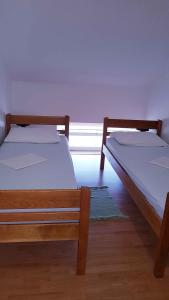 two twin beds in a room with a window at Apartment in Lopar with Two-Bedrooms 1 in Lopar