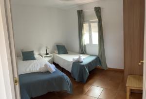 een slaapkamer met 2 bedden en een raam bij Tantulia Bungalows Tamaragua Tenerife in Arona