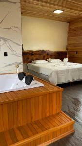 a room with two beds and a bath tub at Pousada Kaluana in Urubici