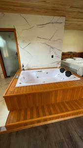 bañera en una habitación con cama en Pousada Kaluana, en Urubici