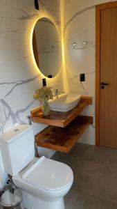 烏魯比西的住宿－卡魯安娜旅館，浴室配有白色卫生间和盥洗盆。