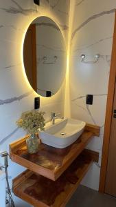 a bathroom with a sink and a mirror at Pousada Kaluana in Urubici