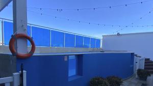 a blue building with a swimming pool with a lifesaver at On Vacation Tower in San Andrés