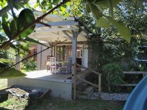 un porche con pérgola, mesa y sillas en Au Temps Suspendu - 3 chambres - Au coeur de la nature - À 10 minutes des commerces en Vielle-Tursan