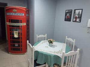 a room with a table and a red telephone booth at Apartamento London - Centro Nova Petrópolis in Nova Petrópolis