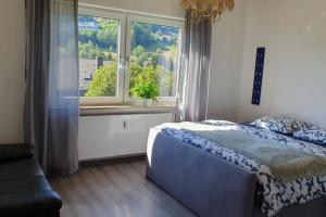 a bedroom with a bed and a large window at Green hills holiday house in Warmensteinach