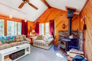 a living room with a fireplace and a stove at Moose Pond Retreat in Bridgton