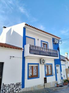 a blue and white house with a balcony at Casa da laranjeira in Montargil