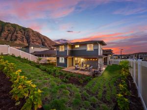 una casa con una recinzione di fronte a una montagna di New Mountainside Home Near Spectacular Beaches a Waianae