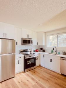 a kitchen with white cabinets and stainless steel appliances at Entire 3 bedroom house in Edmonton