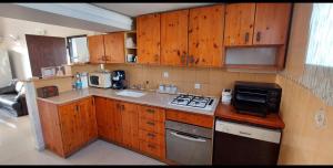 una piccola cucina con armadi in legno e forno a microonde di Apartment 4 Rooms נוה שאנן a Haifa