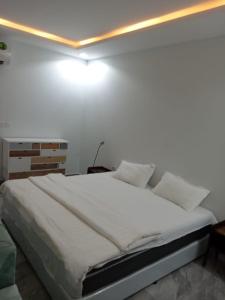 ein weißes Schlafzimmer mit einem großen Bett mit weißer Bettwäsche in der Unterkunft هدي هوم 2 in Buraida
