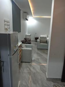ein Wohnzimmer mit einem Kühlschrank und einem Sofa in der Unterkunft هدي هوم 2 in Buraida