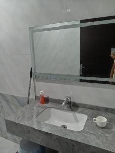 ein Waschbecken mit einem großen Spiegel darüber in der Unterkunft هدي هوم 2 in Buraida