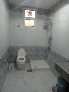 ein weißes Bad mit einem WC und einem Fenster in der Unterkunft هدي هوم 2 in Buraida
