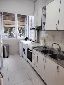 a white kitchen with a sink and a dishwasher at 4ALL Airport 10min,Sea100m,Free parking in Thessaloniki
