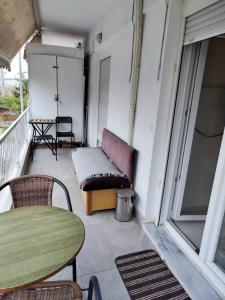 a balcony with a couch and a table and chairs at 4ALL Airport 10min,Sea100m,Free parking in Thessaloniki