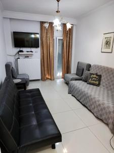a living room with a couch and a tv at 4ALL Airport 10min,Sea100m,Free parking in Thessaloniki