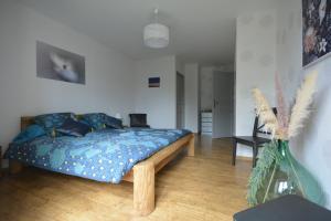Schlafzimmer mit einem Bett mit blauer Decke in der Unterkunft Gîte de Crêt Vial in Alby