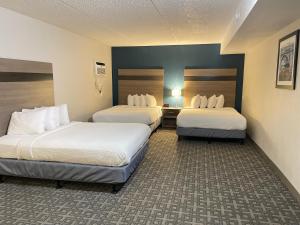 Voodi või voodid majutusasutuse Days Inn & Suites by Wyndham Spokane toas