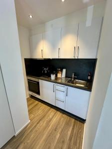 a kitchen with white cabinets and a wooden floor at St.Barbara Trier in Trier