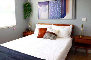 a bedroom with a bed with white sheets and pillows at Luxury Studio Suite close to Tampa Airport in Tampa