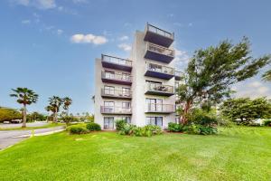 a white apartment building with a grassy yard in front of it at Enclave 2202 in Orlando