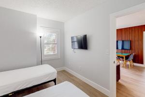 a white room with a bed and a tv at Enclave 2202 in Orlando