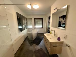 a bathroom with a tub and a sink and a shower at St.Barbara Trier in Trier