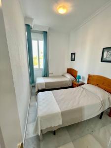 een slaapkamer met 2 bedden en een raam bij El Coloso de SteraM Flats Benalmádena in Benalmádena