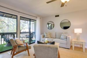 a living room with a couch and chairs and windows at Pinehurst Condo Rental Near Golf with Pool Access! in Pinehurst
