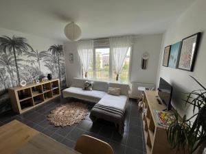 a living room with a couch and a table at Appartement à 5 min de DISNEY proche PARIS in Chanteloup-en-Brie