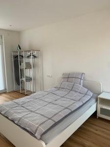a bed in a bedroom with a white wall at Wohnung in Betzingen in Reutlingen
