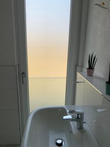 a bathroom with a white sink and a mirror at Wohnung in Betzingen in Reutlingen