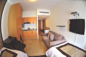 a small living room with a couch and a tv at Bliss 3000 Furnished Studios in Beirut