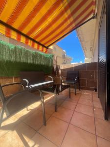 un patio con sedie e un tavolo sul balcone. di Apartment Playa las Vistas a Playa de las Americas