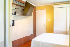 Habitación pequeña con cama y TV. en Amor Building - Urdaneta City 