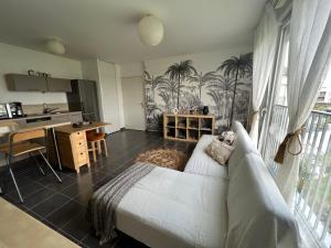 a living room with a bed and a kitchen at Appartement à 5 min de DISNEY proche PARIS in Chanteloup-en-Brie