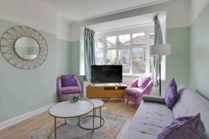 a living room with a couch and two chairs and a tv at Grove House Southend on Sea in Southend-on-Sea