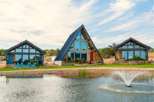 um edifício com um lago e uma fonte em Gruene Daze Chalet - Stylish Aframe - Escape the Ordinary em New Braunfels