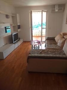 uma sala de estar com um sofá e uma televisão em Rooms and Apartment ANELA with large balcony and beautiful sea view em Dubrovnik