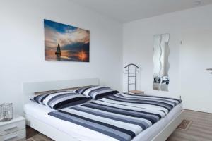 奥斯特巴德·哥伦Ferienunterkünfte Liliane的一间卧室配有一张带两个条纹枕头的床