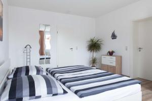 two beds in a white room with at Ferienunterkünfte Liliane in Göhren