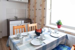 een tafel met kopjes en schotels in de keuken bij Ferienunterkünfte Liliane in Göhren