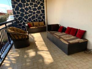 un patio con 2 divani e una sedia sul balcone di VILLA ÉMERAUDE a Yaoundé