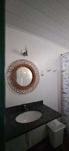 a bathroom with a sink and a mirror on the wall at POUSADA ODARA à Beira Mar in Saquarema