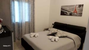 1 dormitorio con 1 cama con toallas en B&B Sensorial Experience, en Villamassargia