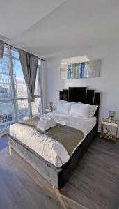 a bedroom with a large bed with a large window at Stunning Luxurious LakeView Condo by CN Tower in Toronto