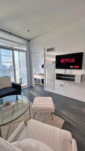 a living room with a couch and a tv on a wall at Stunning Luxurious LakeView Condo by CN Tower in Toronto