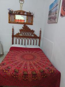1 dormitorio con 1 cama con colcha roja en Amalfi's Place, en Pimentel
